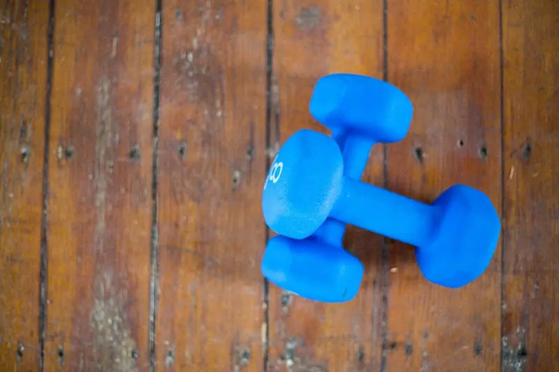 Pair of blue dumbbells on a wooden floor
